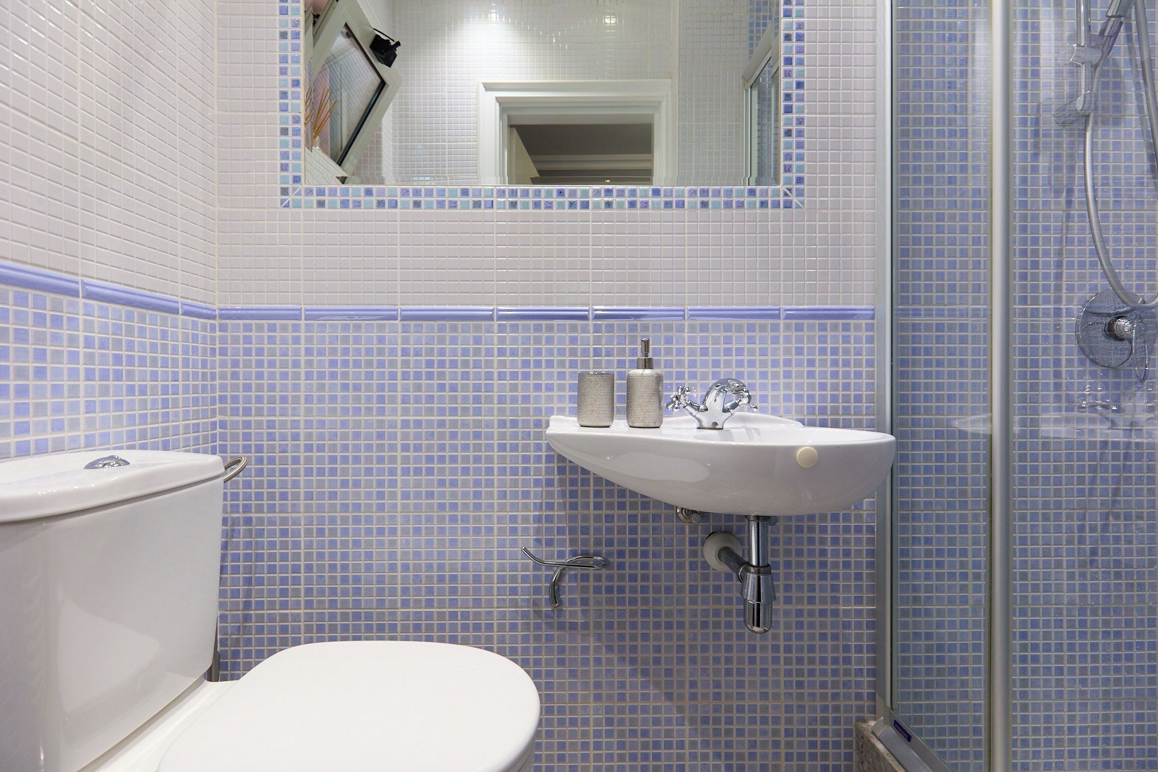 A bathroom with a toilet, sink, and shower.