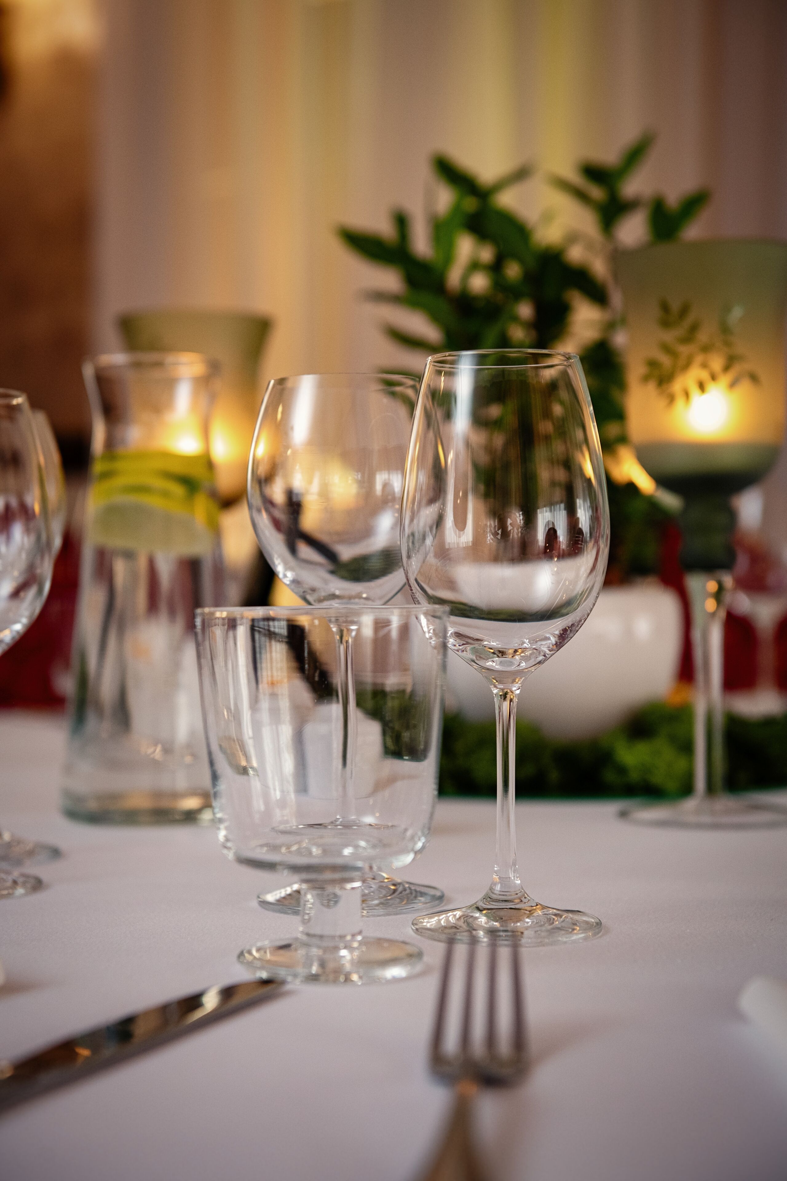 A table set with wine glasses, a fork, and a candle.