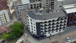 A multi-story hotel with a modern design, featuring a rooftop terrace and a prominent signage for 'TUSDATA'. - Gorukle Alpas Yasam Hotel (Bursa)