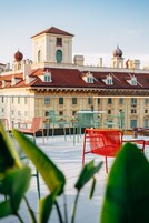 Una terraza con mobiliario exterior y vistas a un edificio histórico de tejados abovedados.