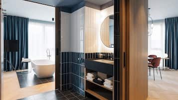 Ein modernes Badezimmer mit freistehender Badewanne, einem Waschtisch mit Spiegel und einer Duschkabine.