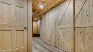 Un pasillo de madera con puertas grandes y una escalera que lleva a otra habitación.