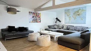 A modern living room with a grey sofa, a white coffee table, and a large world map on the wall. - PRETTY VILLA WITH POOL SLEEPS 8 (Tavel)