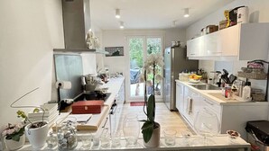 A modern kitchen with a stone island, white cabinets, and a view to the outdoors. - PRETTY VILLA WITH POOL SLEEPS 8 (Tavel)
