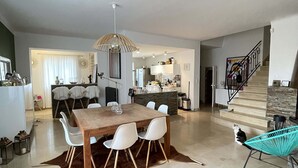 A spacious living area with a dining table, chairs, a sofa, and a staircase. - PRETTY VILLA WITH POOL SLEEPS 8 (Tavel)