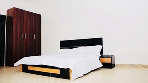 Une chambre à coucher avec un lit, une armoire et une table de chevet.