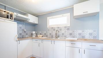 Fridge, microwave, coffee/tea maker, cookware/dishes/utensils