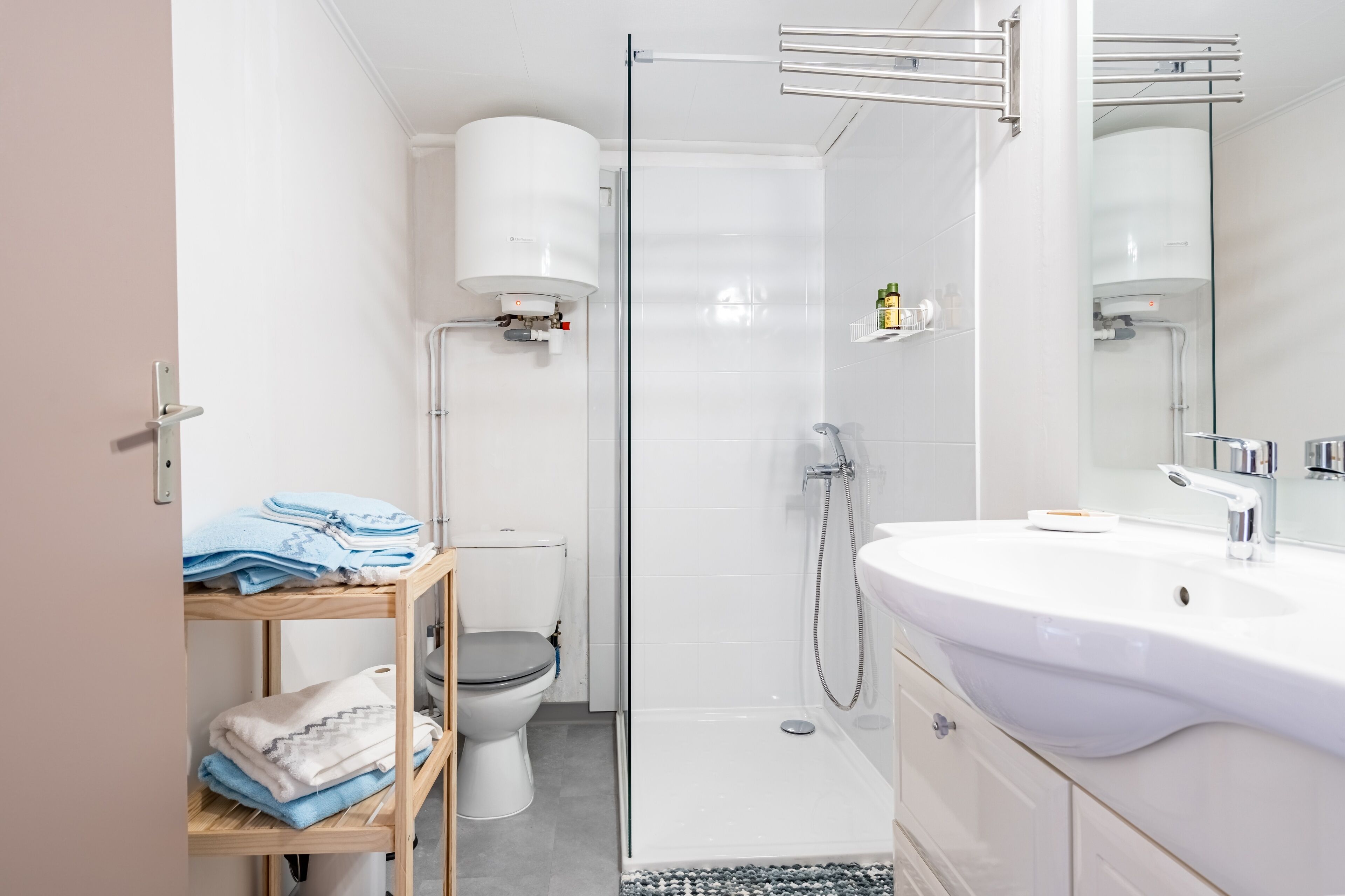 Un baño moderno con cabina de ducha de vidrio, un lavabo blanco y un inodoro.