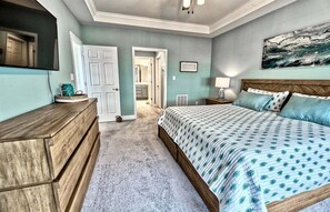 Una camera da letto con un letto, una cassettiera e un quadro appeso al muro.