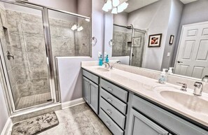 Un bagno con doccia, lavandino e specchio.