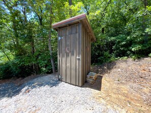 Situated in a wooded area, this secluded retreat features a simple door and window.