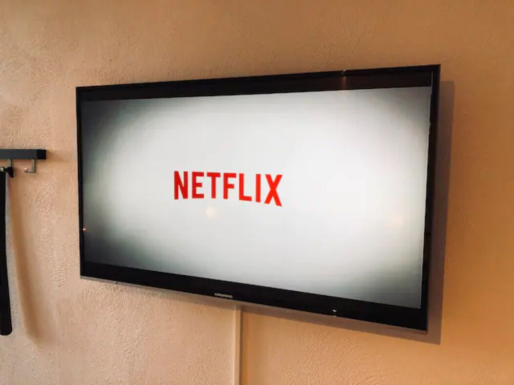 Ein Flachbildfernseher an der Wand, der das Netflix-Logo zeigt.