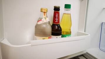 A refrigerator with three bottles of beverages.