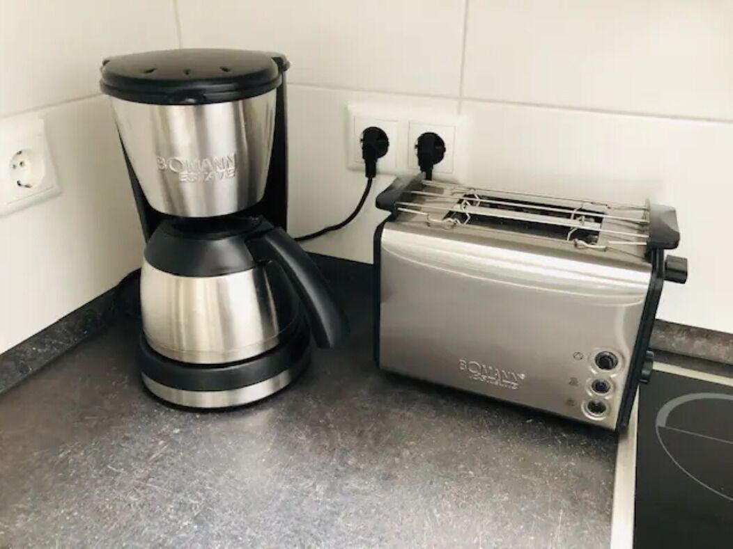 Ett kök med en kaffebryggare och en brödrost på bänkskivan.