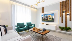 Ein modernes Wohnzimmer mit einer Couch, einem Couchtisch und einem an der Wand befestigten Fernseher.