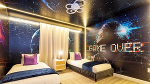 Ein modernes Hotelzimmer mit zwei Betten, einer großen digitalen Wandmalerei und einer Deckenleuchte.