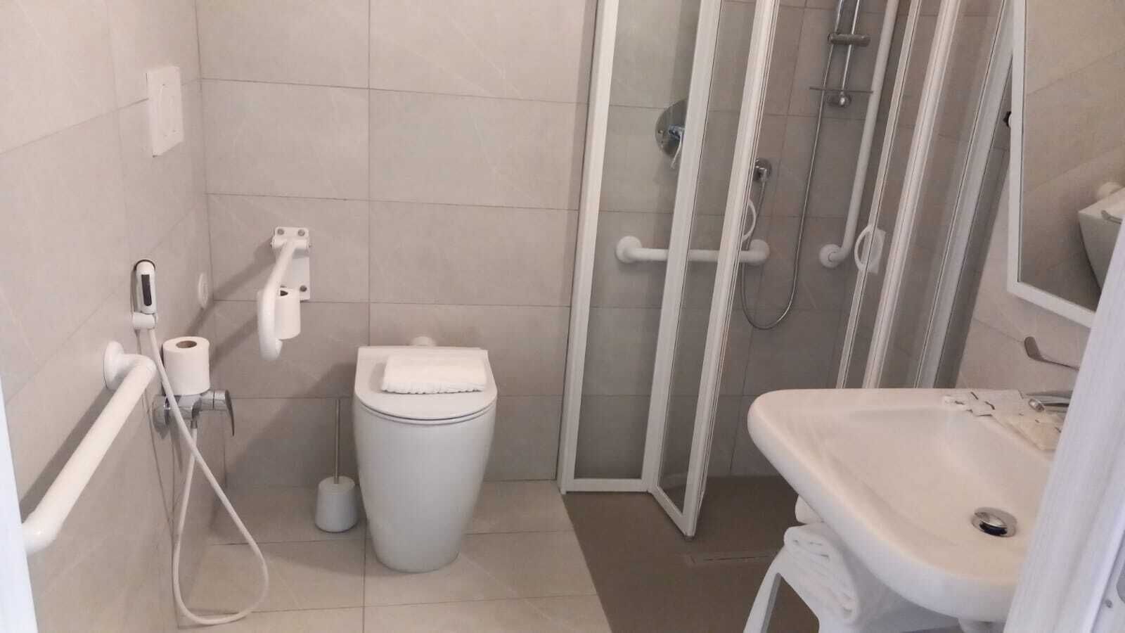 Ein modernes Badezimmer mit Toilette, Duschkabine und Waschbecken.
