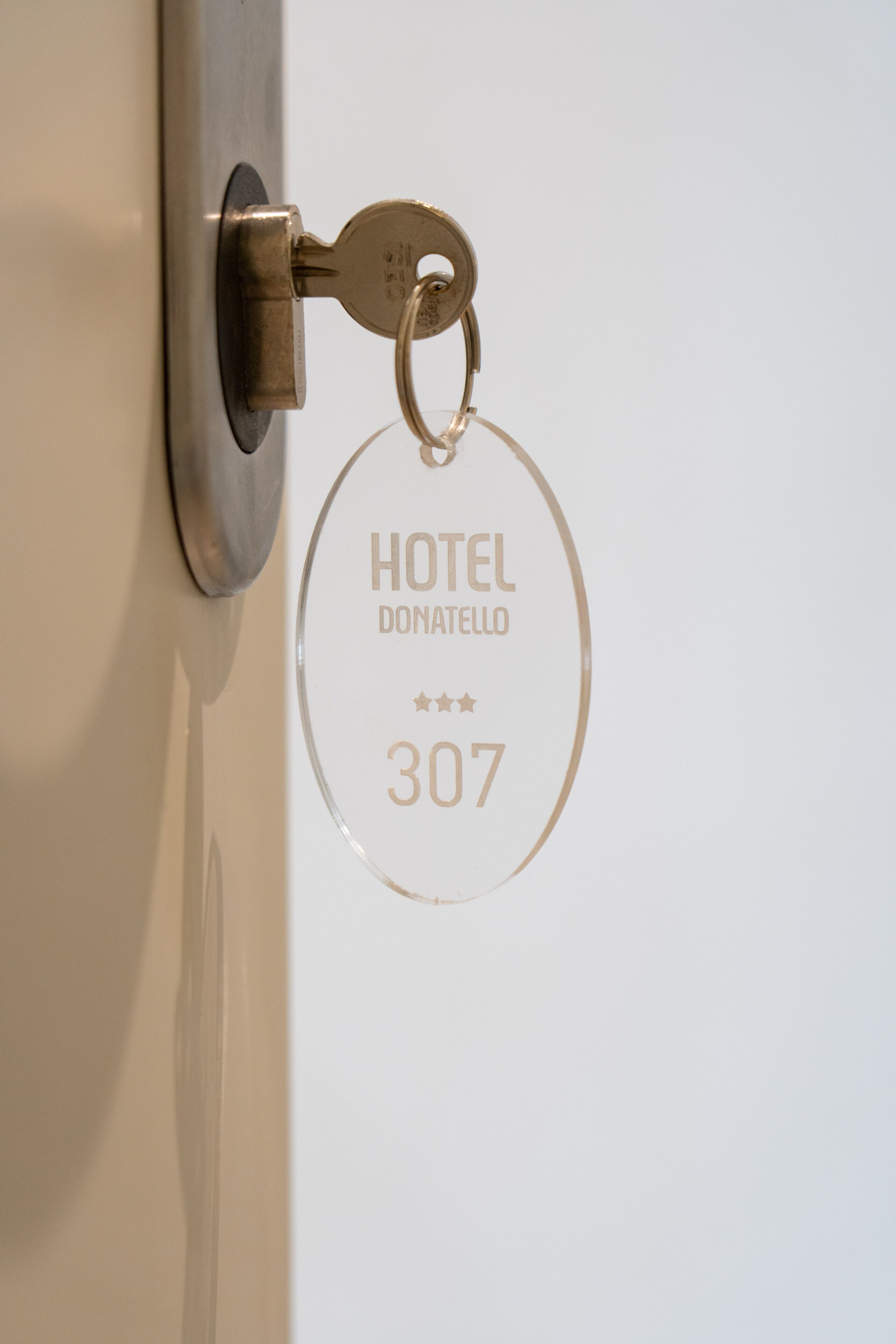 Een sleutelhanger met de tekst 'HOTEL DONATELLO 307' gegraveerd.