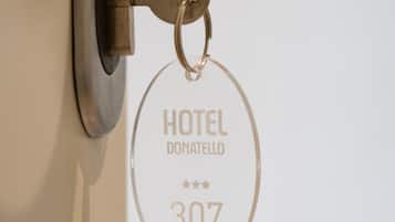 Een sleutelhanger met de tekst 'HOTEL DONATELLO 307' gegraveerd.