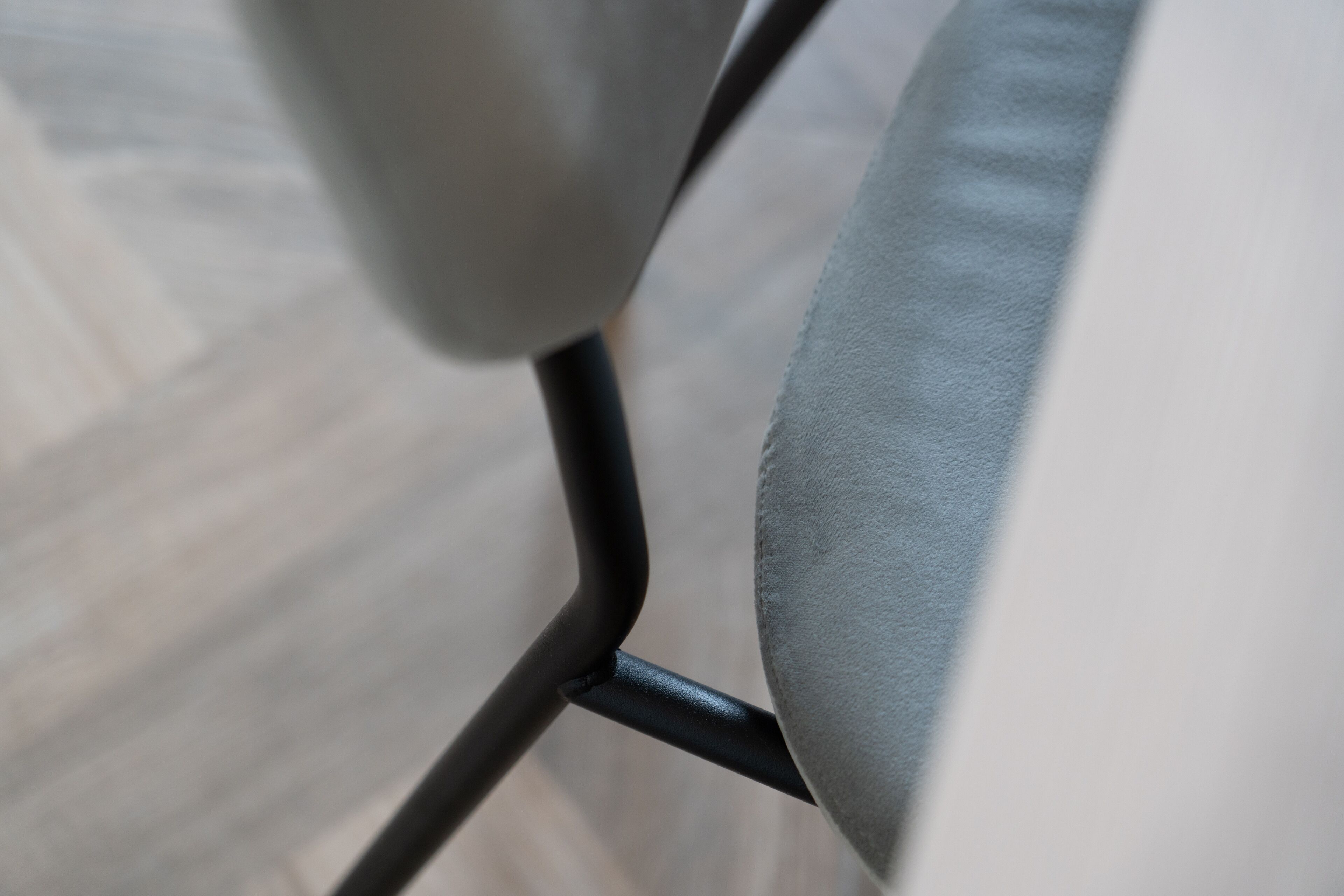Detalle del armazón metálico de una silla y su asiento de tela.