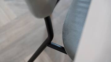 Detalle del armazón metálico de una silla y su asiento de tela.