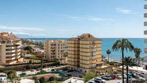A coastal residential area with multi-story buildings, a parking lot, and a view of the sea. - ALFRESCO STAYS  BenalBeach Sea & Sun (Benalmádena)