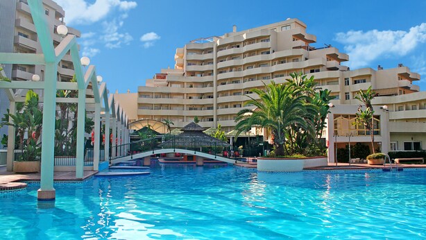 Un hôtel doté d’une piscine, de nombreux balcons et d’un pont reliant les différentes parties de l’établissement.