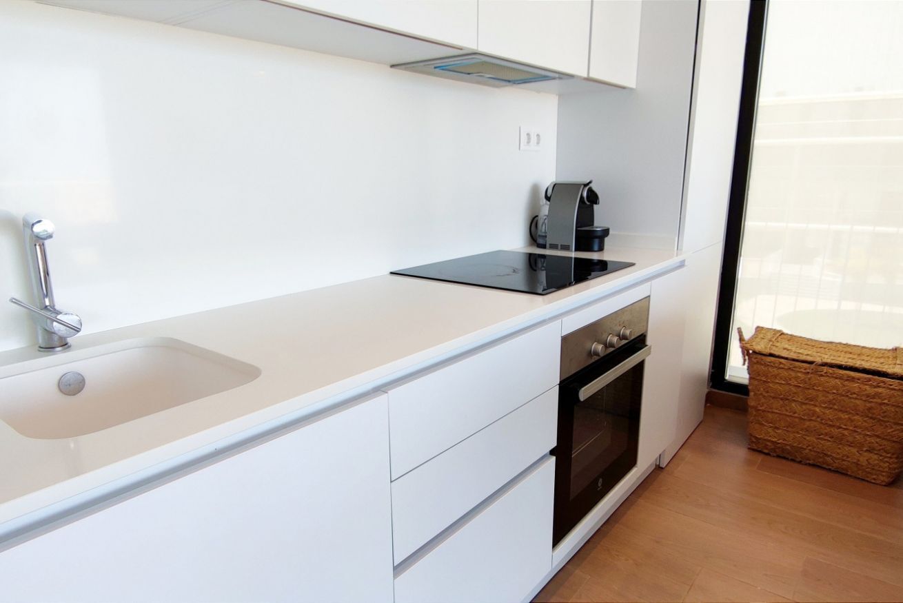 Une cuisine moderne équipée d’un évier, d’une cuisinière et d’une machine à café.