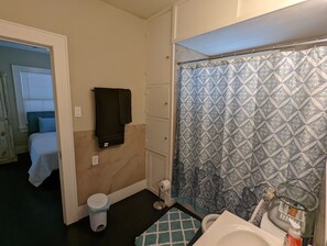 Une salle de bain équipée d’un rideau de douche, de toilettes, d’un lavabo et d’un porte-serviettes.