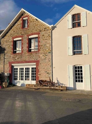 Un bâtiment à deux étages doté d’une façade en pierre et d’une couleur beige.