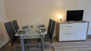 A dining table with chairs, a television, and a cabinet. - Holiday apartment with terrace and air conditioning (Novi Vinodolski)