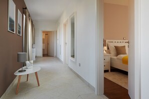 A hallway with a white table, a lamp, and a bed in the adjacent room. - Villa Sonia with private pool, 4 bedrooms and beautiful garden (Stari Grad)