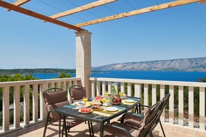 A balcony with a table set for breakfast, overlooking a scenic coastal view. - Villa Sonia with private pool, 4 bedrooms and beautiful garden (Stari Grad)