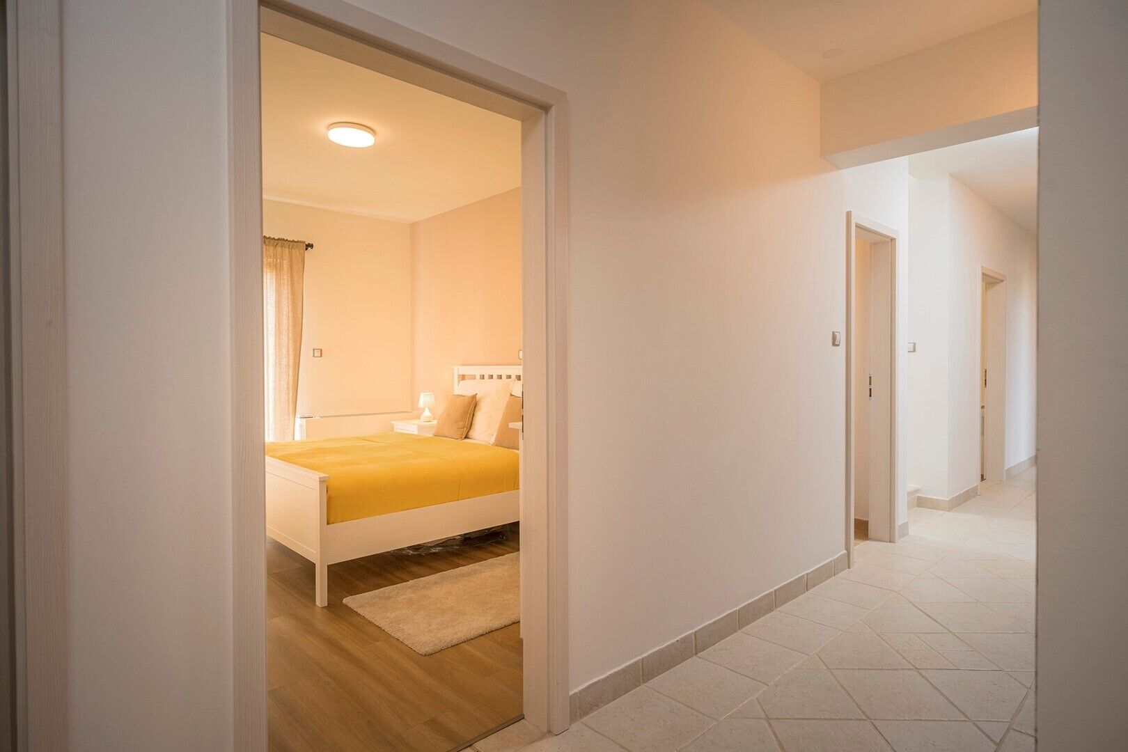 A bedroom with a bed, bedside table, and a nightstand.
