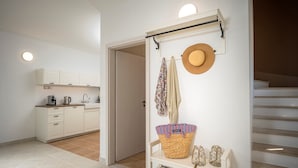 A modern kitchen with white cabinets and a dining area with a white table and chairs. - Holiday villa Stella with private pool and 3 bedrooms (Stari Grad)