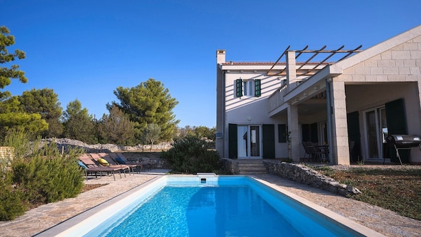 A modern house with a swimming pool, outdoor seating, and a pergola. - Holiday villa Stella with private pool and 3 bedrooms (Stari Grad)