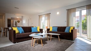 En moderne stue med to sofaer, et sofabord og et spiseområde.