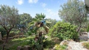 A garden with various plants and a stone pathway. - Villa Alco in Roses with beautiful sea views AV-68 (Rosas / Roses)