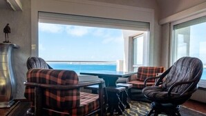A room with a view of the sea, a table, two chairs with plaid upholstery, and a patterned rug. - Villa Alco in Roses with beautiful sea views AV-68 (Rosas / Roses)