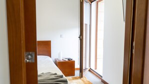 Une chambre à coucher avec un lit, une table de chevet et une fenêtre.
