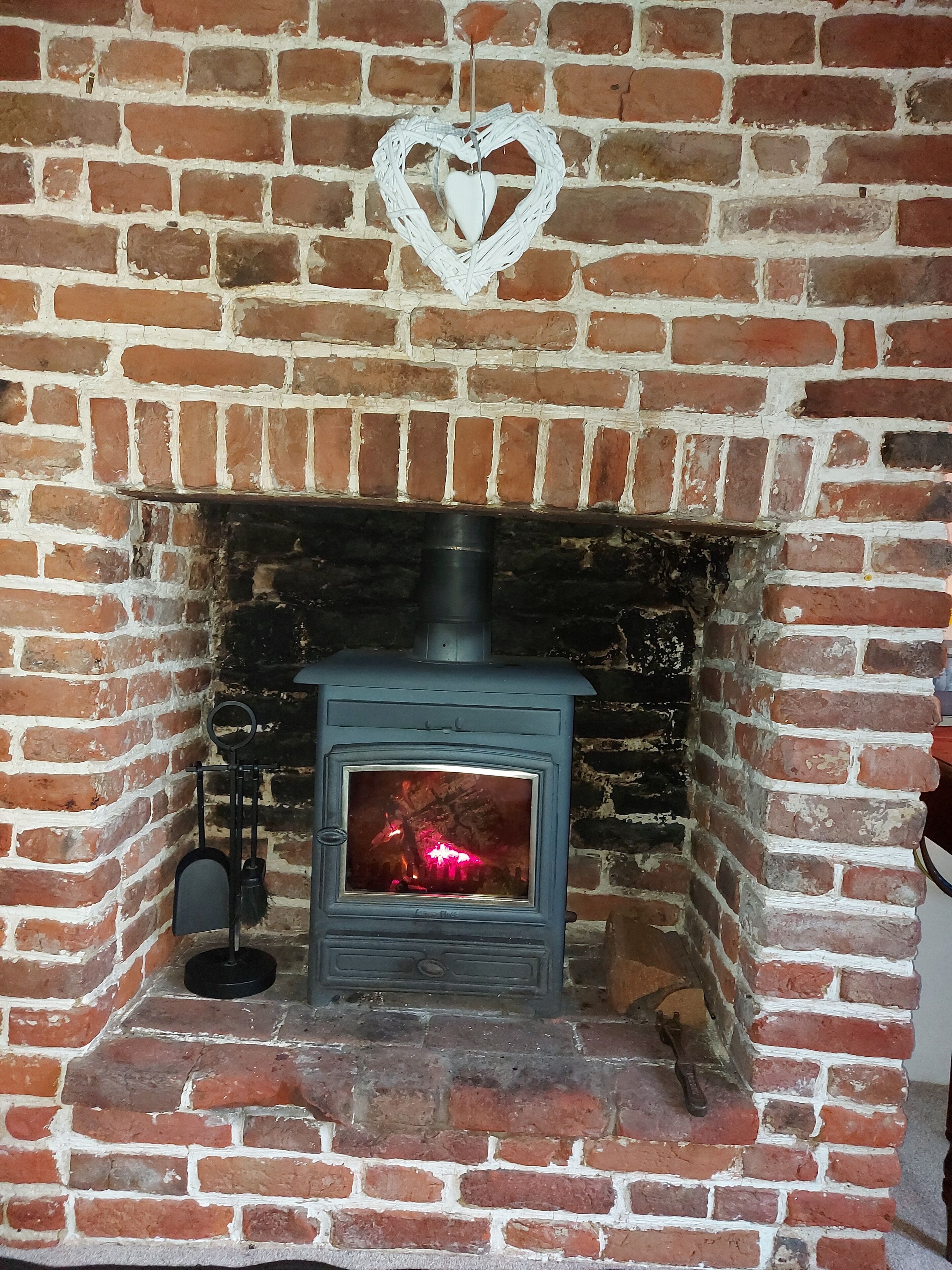 Una chimenea de ladrillo con un adorno en forma de corazón.