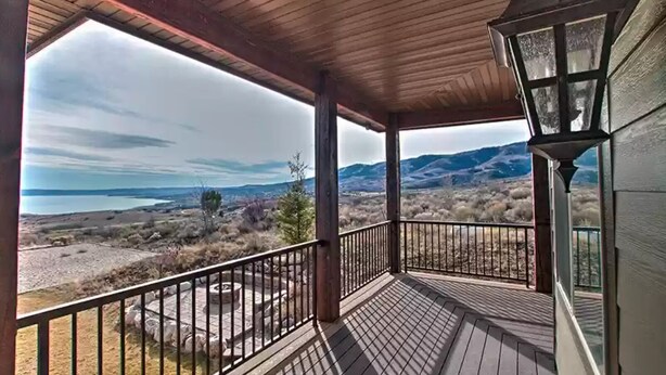 A covered porch with a view of a lake and mountains. - 7 acre Estate in Gated Reserve Community with Access to Pools, Beach, & Trails (Fish Haven)