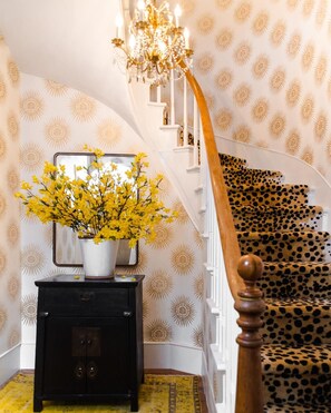 Stunning curved staircase takes center stage, flanked by unique patterns and elegant design.