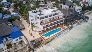 A multi-story hotel with a pool and beach access. - Pili Pili Family (Jambiani)