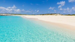 Una spiaggia con acque cristalline turchesi e sabbia bianca.