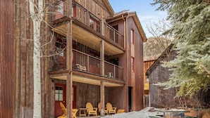 A rustic wooden building with a balcony and outdoor seating area.