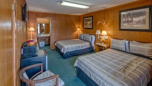 Une chambre d’hôtel avec deux lits, un bureau, une chaise, une télévision et un tableau encadré au mur.