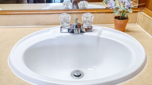 Un évier blanc avec un robinet chromé et un drain.