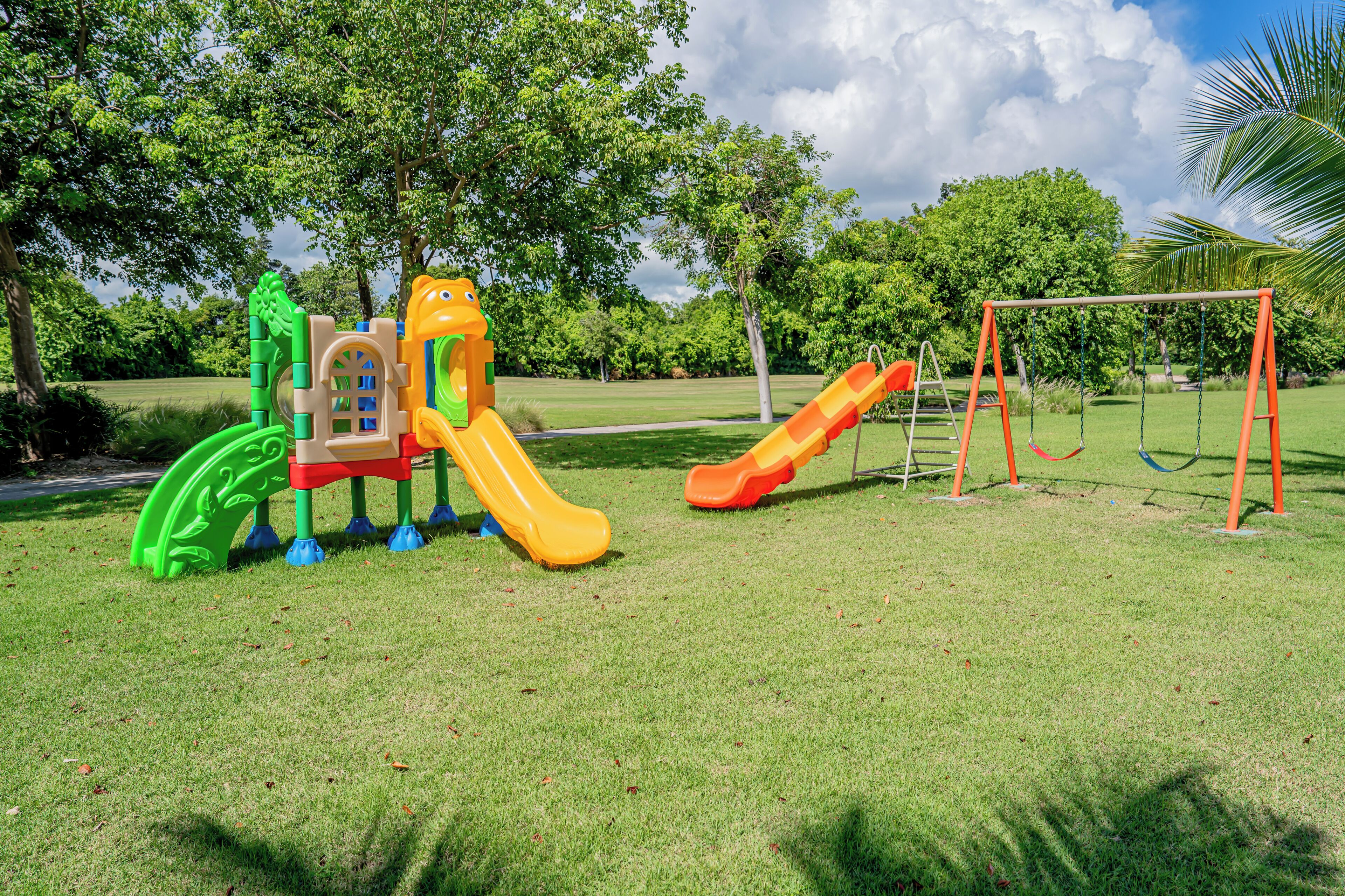 A playground with a slide, climbing structure, and swings.