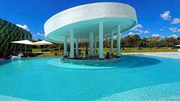 Ein großer, kreisförmiger Pool mit klarem, blauem Wasser, umgeben von einem weißen Pavillon mit Säulen.